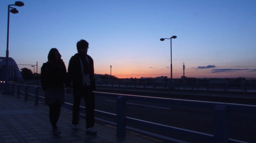 在《親密》中，兩位主角在多摩川的丸子橋上，從黑夜凌晨走到黎明曙光的顯現，都是攝影本體論——攝影鏡頭作為時間的紀錄本質得以彰顯。（擷取自電影《親密》）